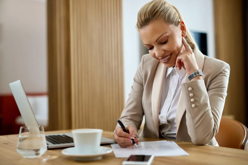 Foto de uma mulher empresária assinando um contrato de parceria com outra empresa B2B após meses de relacionamento de valor.