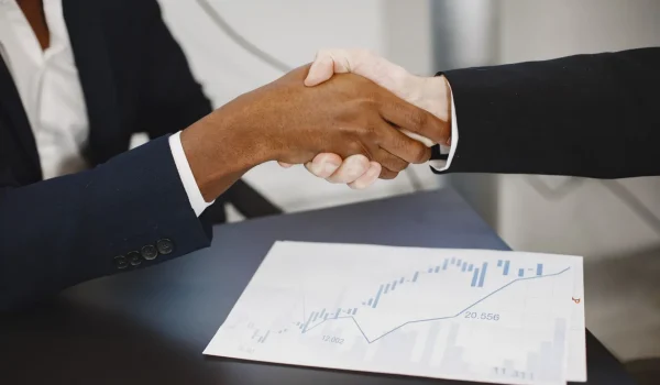 Foto de um aperto de mãos entre empresários, representando a parceria de negócios da Agência Mutum, especialista em gerar demanda qualificada via Marketing B2B, com empresas de SaaS, tecnologia, indústria, engenharia, construção civil e outros setores B2B técnicos.