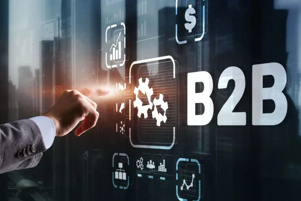 Foto da mão de um profissional interagindo com uma tela digital que exibe elementos relacionados a negociação entre empresas, representando a elaboração de uma estratégia de marketing B2B.