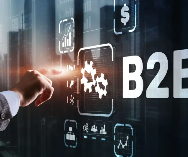 Foto da mão de um profissional interagindo com uma tela digital que exibe elementos relacionados a negociação entre empresas, representando a elaboração de uma estratégia de marketing B2B.