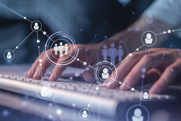 Imagem de ícones de perfis conectados flutuando em cima do teclado de um profissional de marketing elaborando uma estratégia de geração de leads B2B.