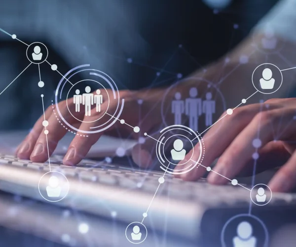 Imagem de ícones de perfis conectados flutuando em cima do teclado de um profissional de marketing elaborando uma estratégia de geração de leads B2B.